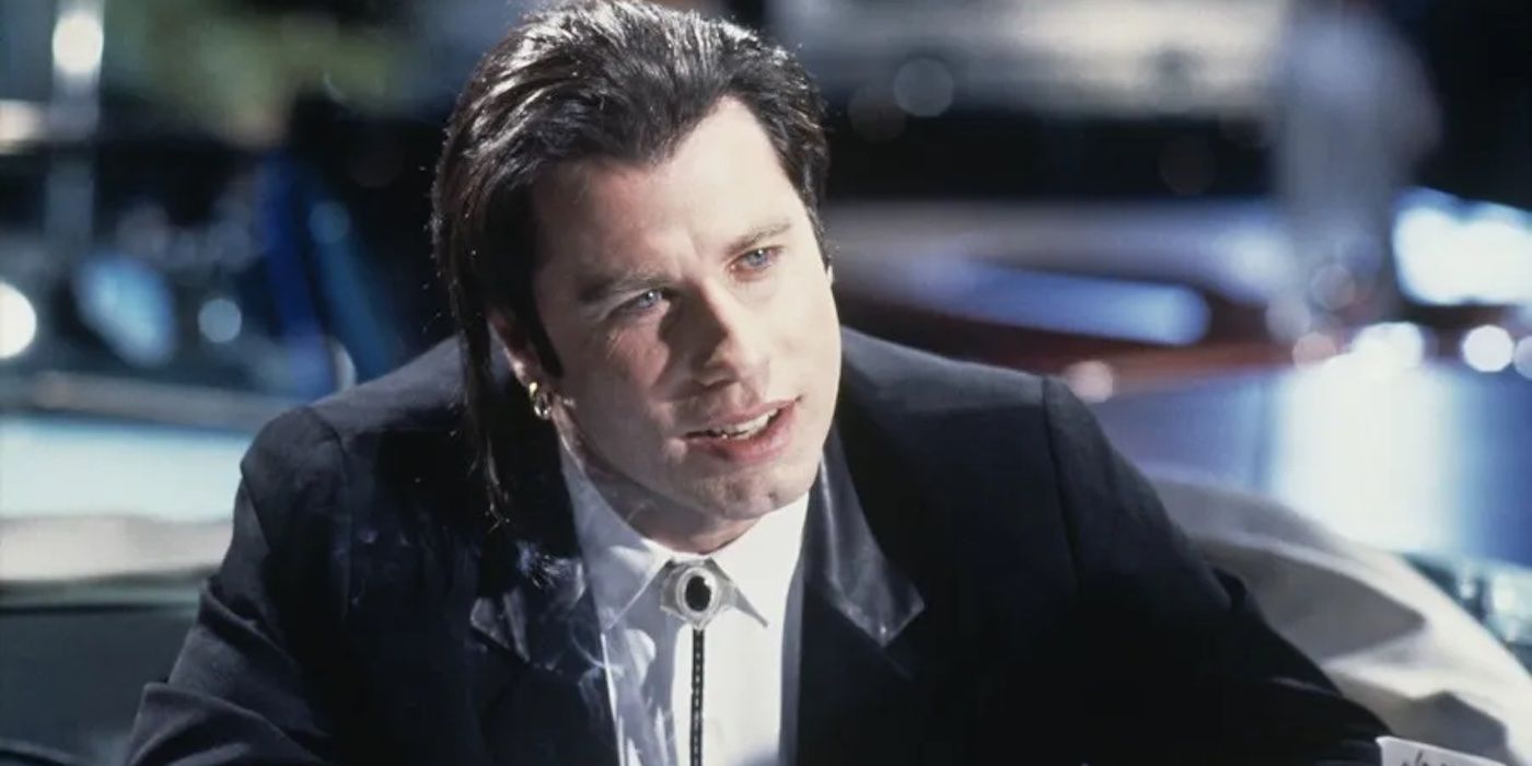 John Travolta as Vincent Vega in Pulp Fiction wearing a white shirt and a black jacket