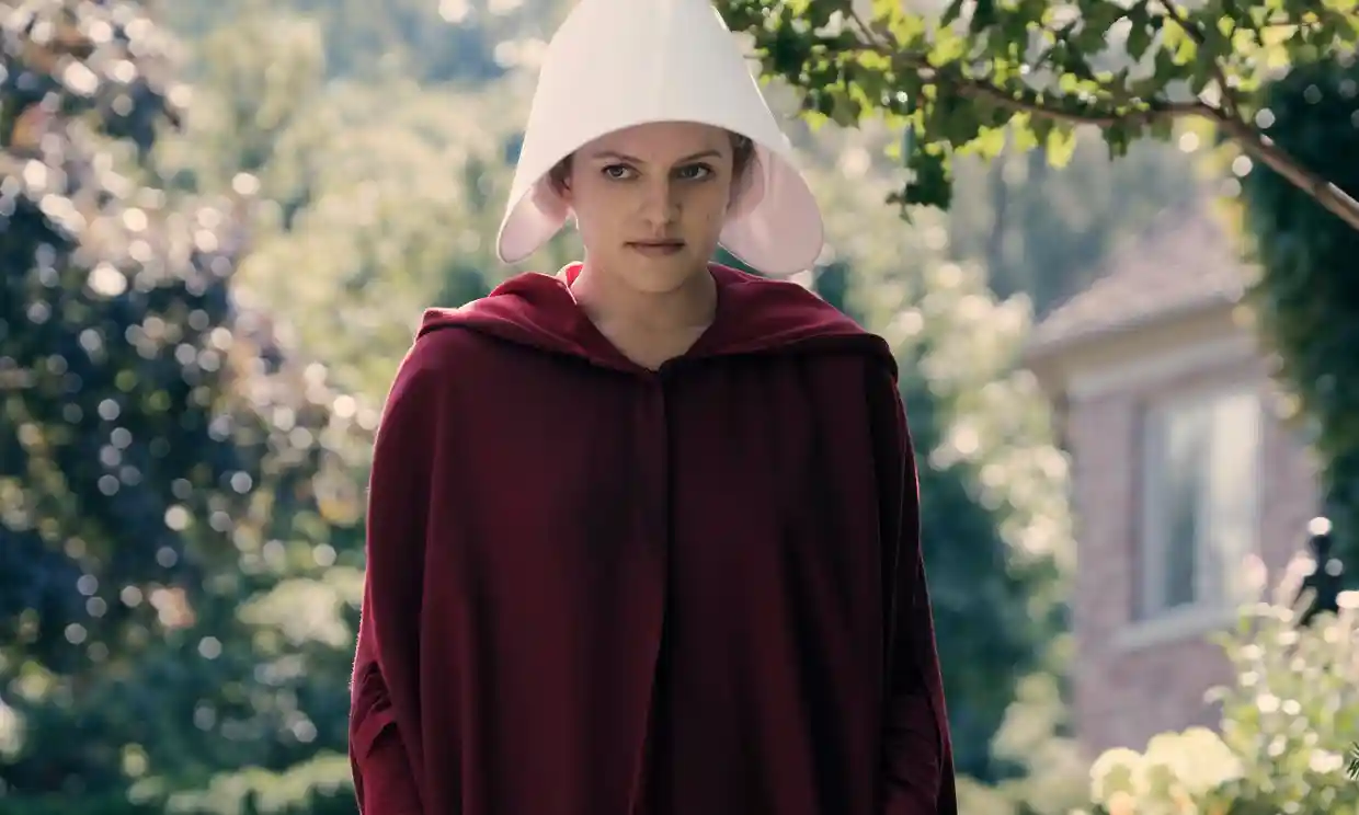 Offred venturing out into the streets, dressed in her red handmaid's outfit.