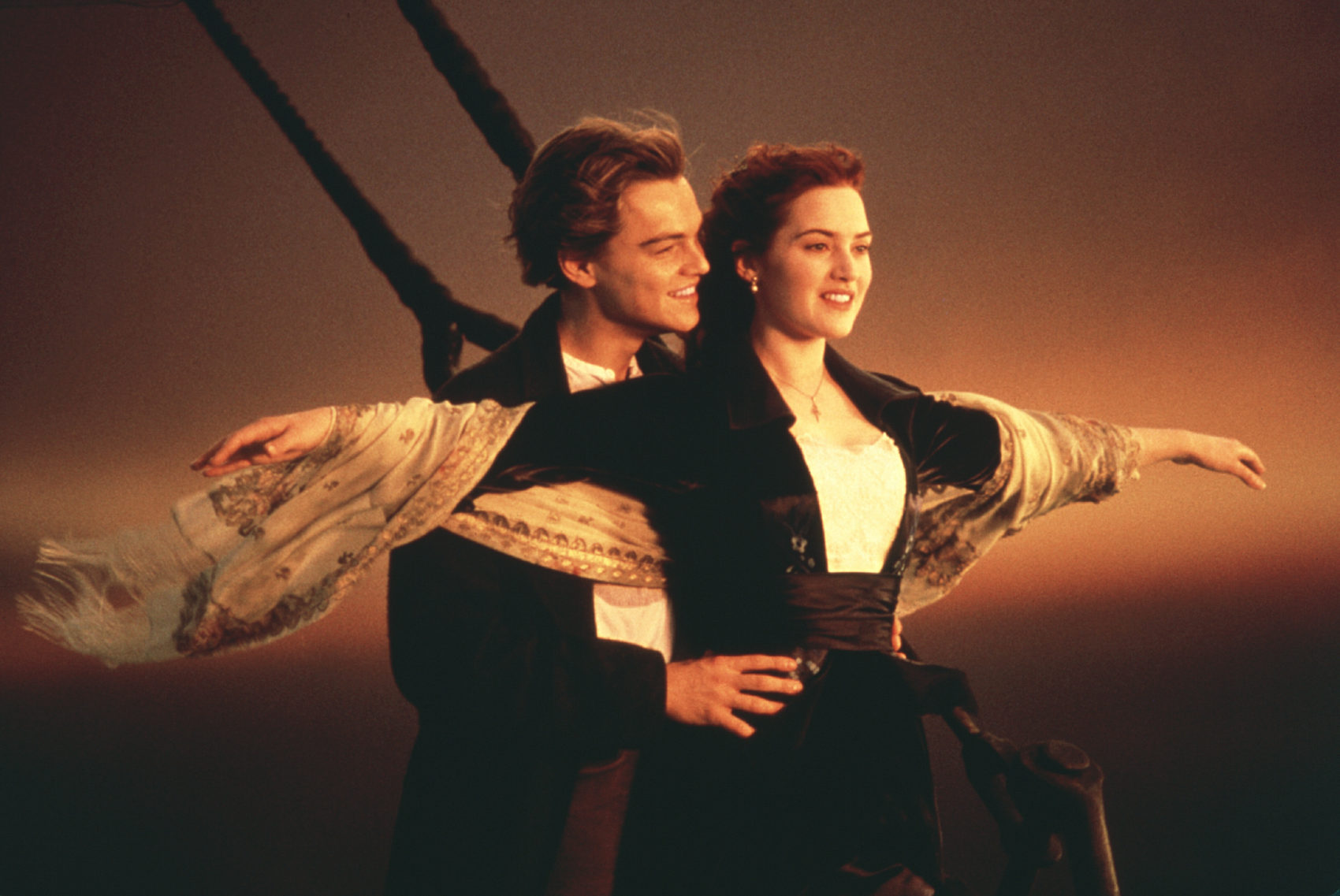 Jack and Rose standing aboard the deck of the Titanic looking out towards the ocean. Rose has her arms outstretched
