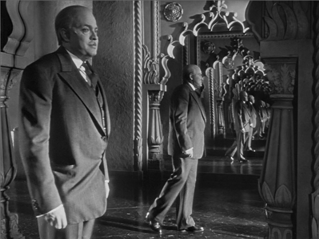 Charles Foster Kane as an older man is seen from a side angle, we can also see his reflection in the mirror. 