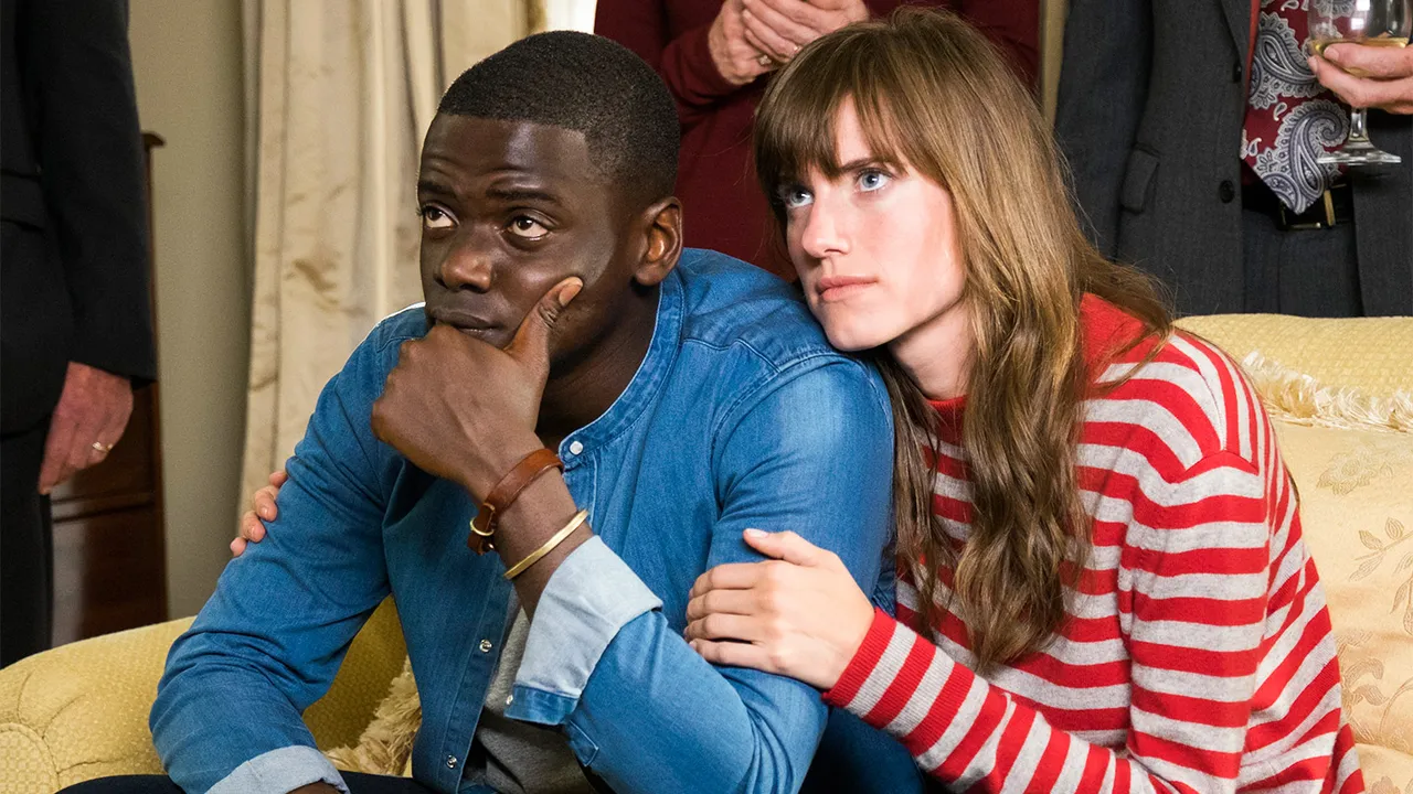 Chris (Daniel Kaluuya) and Rose (Allison Williams) sitting on her parent's couch.