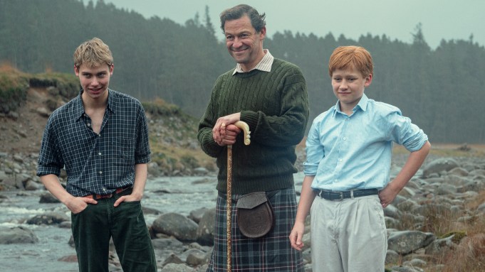 Dominic West as Prince Charles in the Crown posing in the Scottish Highlands with his two children Prince William and Prince Harry in 1997