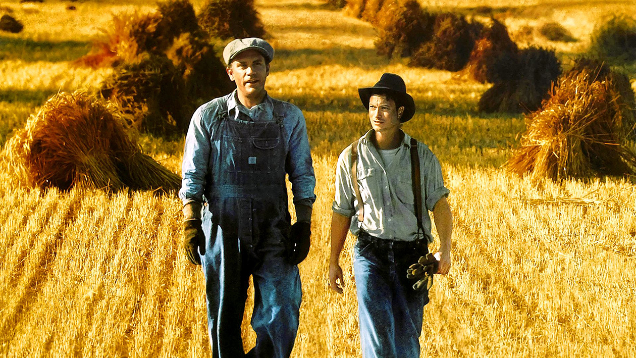 George and Lennie in the 1992 film adaption of Of Mice and Men in a field of wheat basking in the setting sun.