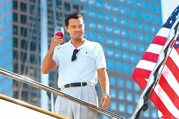 Jordan Belfort raising a glass aboard his luxury boat which he bought with the proceeds of his financial crime.