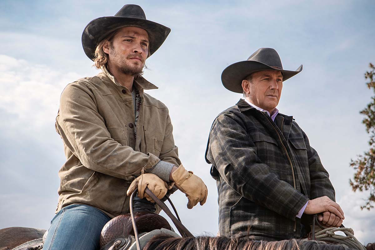 John Dutton III and his son Kayce Dutton riding on horseback looking at something off camera
